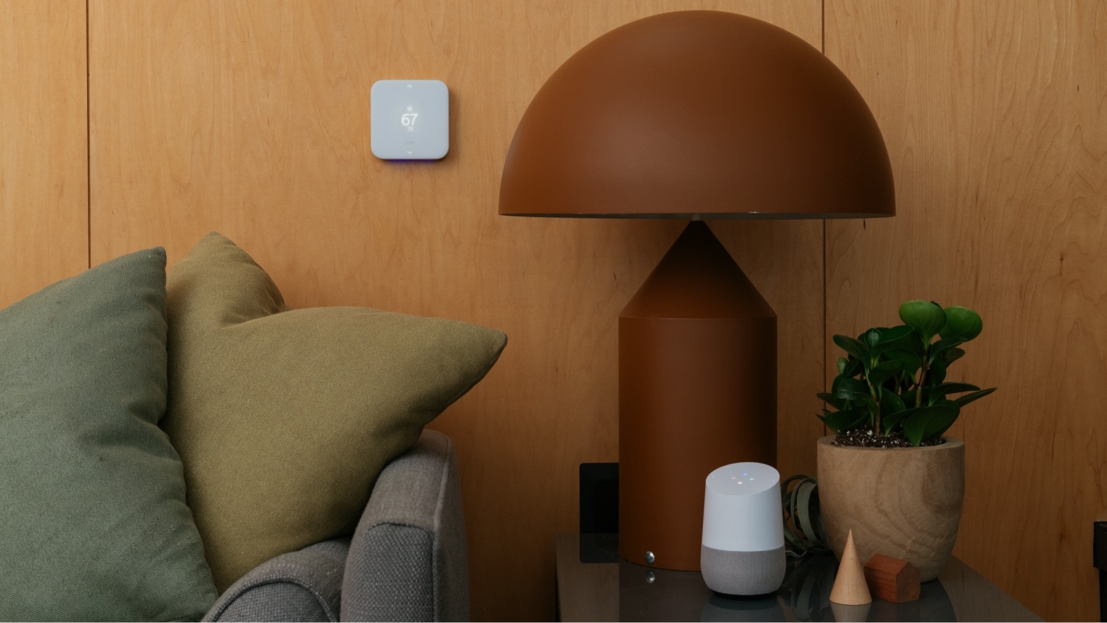 Vivint Smart Thermostat installed in a living room with a Google Home on a side table.