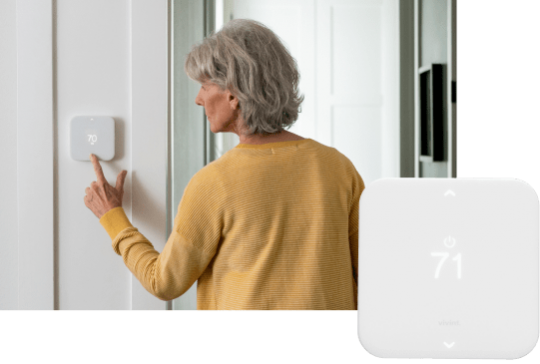 Woman lowering the temperature on the Vivint Element Thermostat with product image of thermostat in bottom right corner